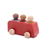 Wooden toy train car with three spherical wooden figures on a white background